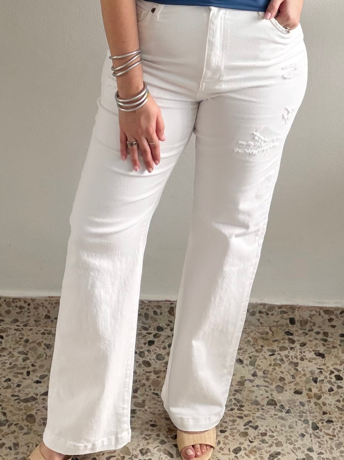 Person wearing white jeans on a neutral background